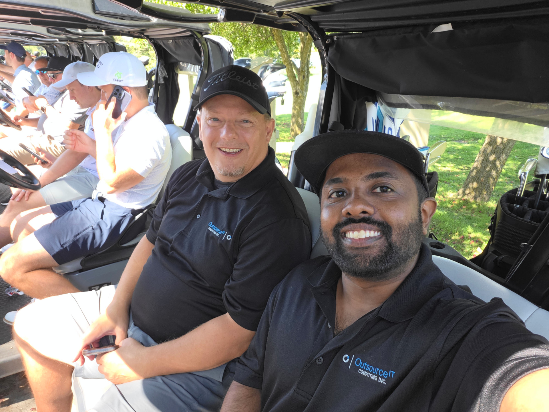 Outsource IT team members in a golf cart before the shotgun start